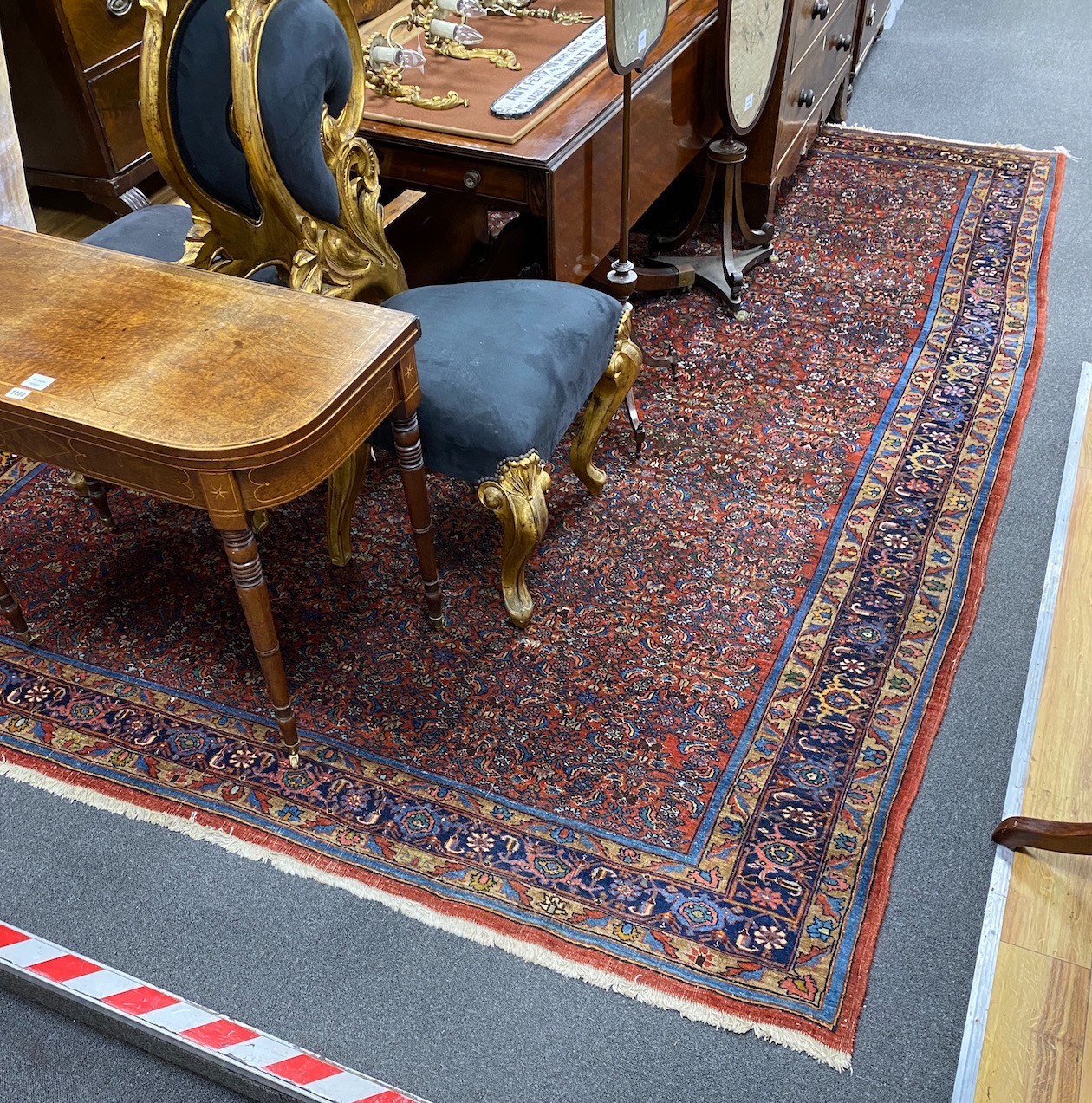 A North West Persian red ground carpet with dense floral field within a triple border, 360 x 250cm